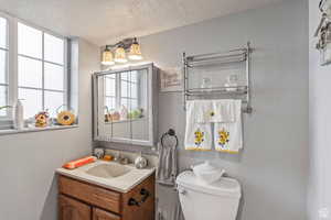Half bath with vanity and a textured ceiling