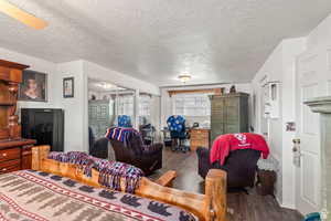 Living room featuring wood finished floors, a desk, and a textured ceiling