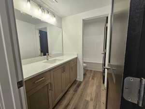 Full bath with vanity, dark wood-type flooring, and shower / tub combination