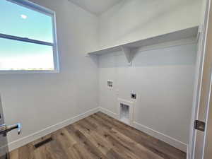 Washroom with wood finished floors, washer hookup, and electric dryer hookup