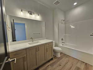 Bathroom with vanity, light wood-type flooring, shower / tub combination, and recessed lighting