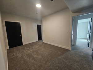 Spare room with dark colored carpet