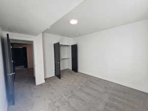 Unfurnished bedroom with light carpet and a closet