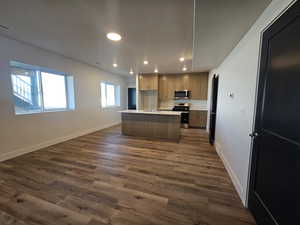 Kitchen featuring light countertops, recessed lighting, stainless steel appliances, a center island with sink, and open floor plan