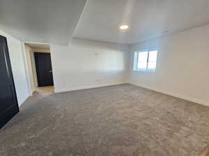 Carpeted spare room with baseboards and recessed lighting