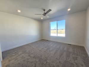 Unfurnished room with dark carpet, recessed lighting, and a ceiling fan