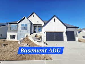 View of front of home with driveway, board and batten siding, brick siding, and a garage
