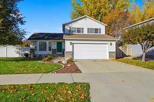 Traditional-style house with concrete driveway, brick siding, and a garage