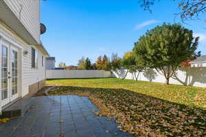 Fenced backyard featuring french doors and a patio area