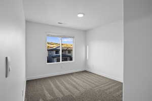 Spare room featuring carpet and baseboards