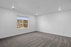 Carpeted empty room featuring recessed lighting