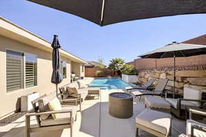 View of swimming pool with an outdoor living space with a fire pit, a fenced backyard, and a patio area