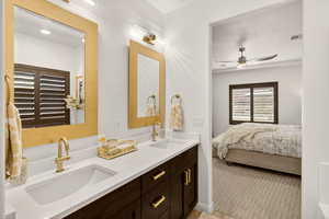Bathroom with ensuite bath, double vanity, and ceiling fan