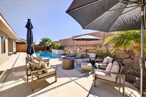 View of swimming pool with a patio area, an outdoor living space with a fire pit, and a fenced backyard