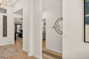 Hall featuring light wood finished floors and a chandelier