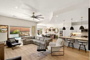 Living area with light wood-style flooring, ceiling fan, a textured ceiling, and recessed lighting