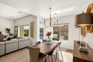 Dining space featuring a chandelier, light wood-style flooring, a textured ceiling, and recessed lighting