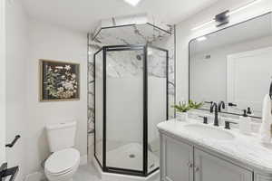 Bathroom with vanity, a marble finish shower, and light tile patterned floors