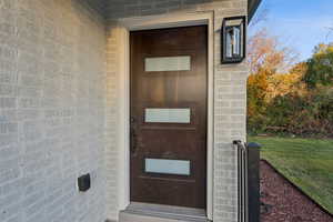 View of exterior entry with brick siding