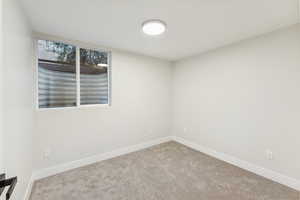 Carpeted spare room with baseboards