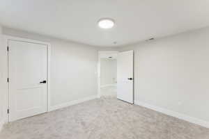 Unfurnished bedroom featuring baseboards and light colored carpet