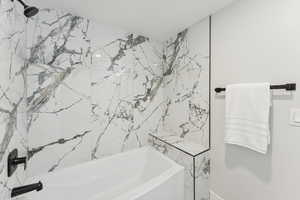 Full bathroom with a combined bath / shower with marble appearance