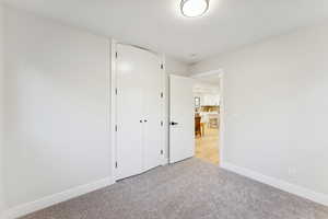 Unfurnished bedroom with carpet, a closet, and a textured ceiling