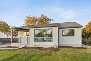 Back of property featuring brick siding and a shingled roof