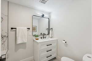 Bathroom with vanity and a textured ceiling