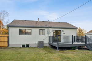 Back of property featuring brick siding, a deck, and a shingled roof