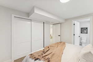 Carpeted bedroom featuring a closet and connected bathroom