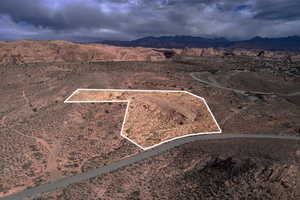 Aerial view of sparsely populated area with property boundaries highlighted and a mountain backdrop