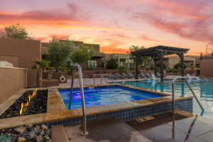 Pool at dusk with a community pool, a pergola, a patio, and a community hot tub