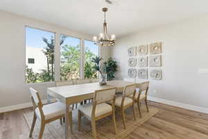 Dining area featuring light wood-type flooring and a chandelier