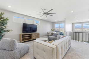 Carpeted living room featuring ceiling fan and recessed lighting