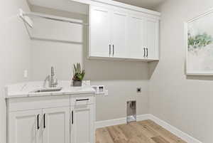 Laundry room featuring light wood-style floors, washer hookup, hookup for an electric dryer, and cabinet space