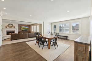 Dining area featuring a brick fireplace, wood finished floors, and recessed lighting