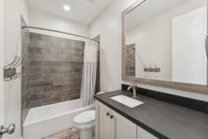 Bathroom with shower / bath combination with curtain, vanity, and recessed lighting