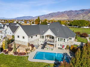 Back of property featuring stone siding, a patio, stairway, french doors, and a residential view