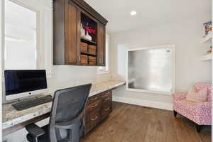 Home office featuring built in study area, dark wood-style flooring, and recessed lighting