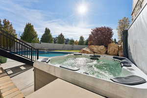 View of pool with a fenced backyard, a hot tub, and a patio