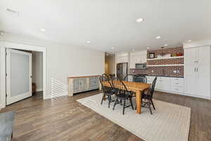 Dining area with recessed lighting and dark wood-style floors
