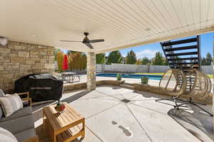 Fenced backyard featuring a patio area, stairway, a ceiling fan, and a grill