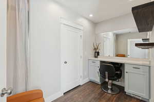 Home office featuring dark wood-style floors, built in desk, and recessed lighting