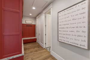 Corridor with light wood-type flooring and recessed lighting