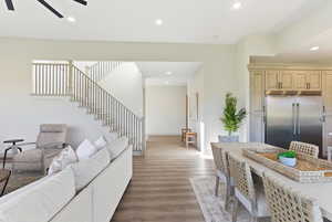 Living area featuring wood finished floors, stairs, recessed lighting, and ceiling fan