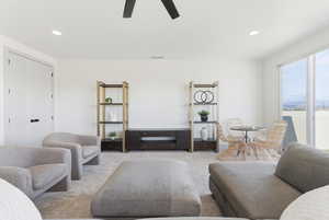 Carpeted living area with recessed lighting and ceiling fan
