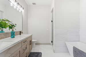 Bathroom featuring double vanity, a freestanding bath, and a shower stall