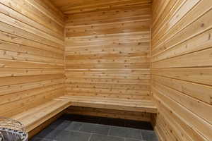 Sauna / steam room featuring tile patterned flooring, wooden walls, and wood ceiling