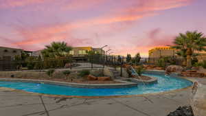 Pool at dusk featuring a patio area